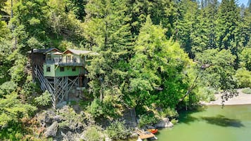 Escape to a serene lakeside retreat, surrounded by lush greenery and accessible via a staircase to the water's edge.