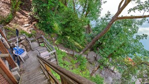 A wooden staircase leading to a deck with a chair and paddleboard. - Unwind on the River, Views, Beaches, Dog Friendly (Forestville)