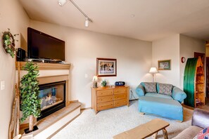 Cozy living room with a fireplace, TV, and comfortable seating area.