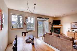 Relax in this inviting living area with a dining table, comfortable sofa, and fireplace.