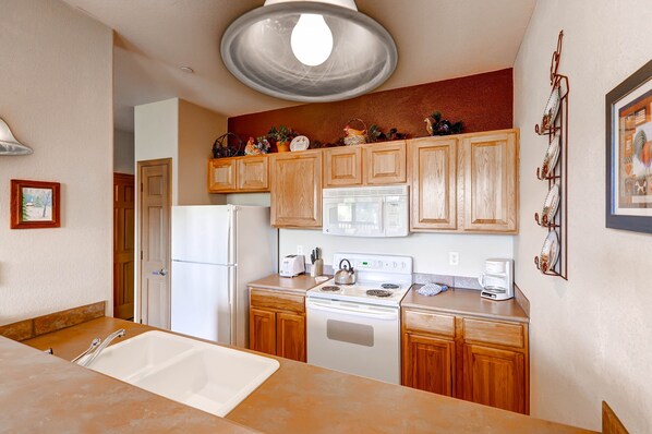 Enjoy cooking in this fully equipped kitchen with a stove, microwave, and coffee maker.