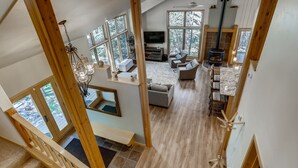 Un loft spacieux avec de hauts plafonds, de grandes fenêtres, une cheminée, un coin repas et un espace salon confortable.