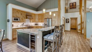 Une cuisine spacieuse avec des meubles en bois, un grand îlot central et des appareils électroménagers modernes.