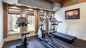 Ein Fitnessstudio mit Laufbändern, Crosstrainern und Fahrrädern.