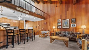 Un intérieur en bois comprenant un coin repas, un canapé et une cuisine.