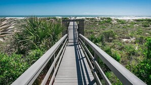 A wooden boardwalk leading to a beach with a clear view of the ocean. - Oceanfront Family Condo in St. Augustine (Saint Augustine)