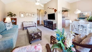 Un ampio soggiorno con divano, tavolino e televisione. È presente anche una zona pranzo con tavolo e sedie.