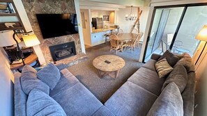 Relax in this spacious living room with a comfortable sofa, dining area, and fireplace.