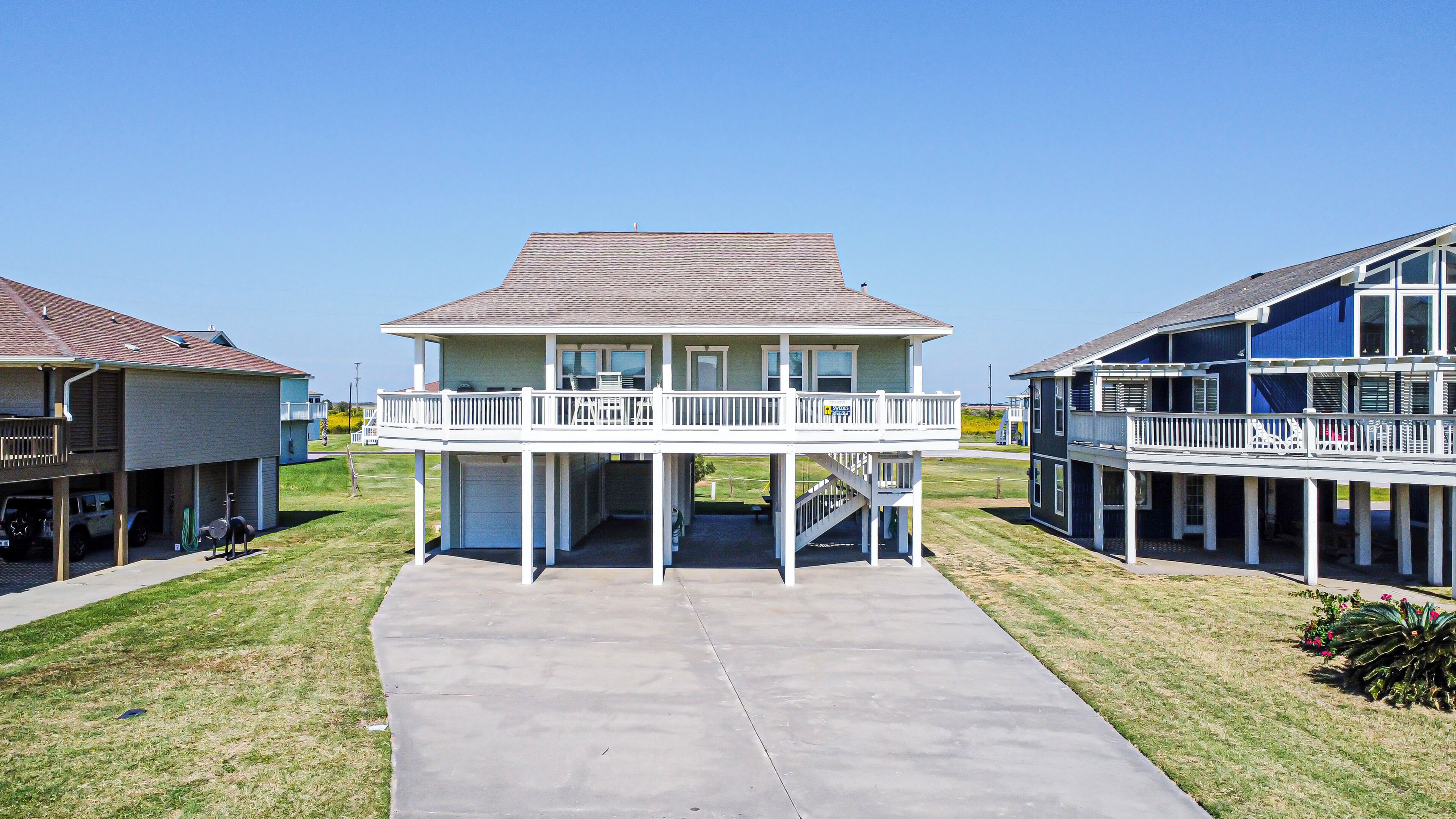 A two-story house with a balcony, a garage, and a driveway.