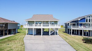 A two-story house with a balcony, a garage, and a driveway.