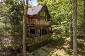 A log cabin with a balcony, surrounded by trees. - Mountain Escape w/ Fire Pit, Pool Table & Hot Tub! (OAKLAND)