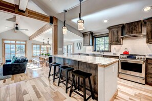 A spacious kitchen with a large island, wooden cabinets, and a modern stove. - Beautiful new 4 bed/4bath private home, 4 blocks off Main St with all the amenities!! (Frisco)