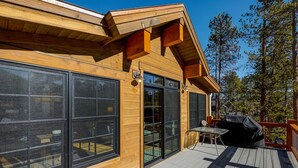 A modern wooden cabin with large windows, a deck, and outdoor seating. - Beautiful new 4 bed/4bath private home, 4 blocks off Main St with all the amenities!! (Frisco)