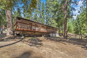 A cabin with a deck, surrounded by trees. - Large Deck, Bunk Room, Garage, Close to Waterman's Landing "Agate Bay Ranch" (Carnelian Bay)
