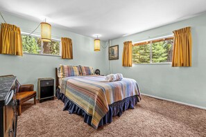 A bedroom with a bed, a desk, a chair, and a window with curtains. - Large Deck, Bunk Room, Garage, Close to Waterman's Landing "Agate Bay Ranch" (Carnelian Bay)