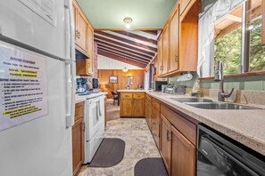 A compact kitchen with wooden cabinets, a built-in oven, a sink, and a stove. - Large Deck, Bunk Room, Garage, Close to Waterman's Landing "Agate Bay Ranch" (Carnelian Bay)