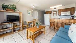 A compact living space with a kitchenette, a dining area, a TV, and a sofa. - Florence I 706 - Bargain beachfront vacay;Shining pool;Prime locale (South Padre Island)