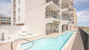 A rooftop pool with lounge chairs and a view of the ocean. - Florence I 706 - Bargain beachfront vacay;Shining pool;Prime locale (South Padre Island)