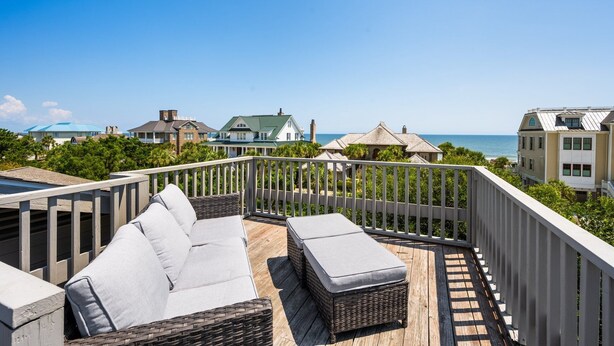 A balcony with wicker furniture and a view of the ocean. - Natural and Serene Home Away from Home (Georgetown)