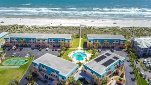 A beachfront hotel with a central pool, multiple parking lots, and a beach view. - Oceanfront Family Retreat in St. Augustine (Saint Augustine)