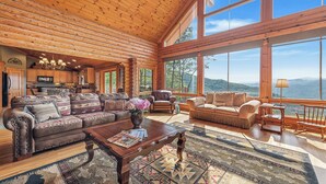 Un intérieur spacieux de chalet en bois, avec un grand salon, une cuisine et une vue sur les montagnes.