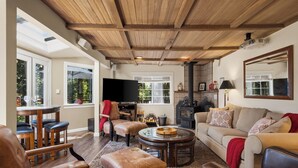 Una sala de estar con chimenea, televisor y comedor con mesa y sillas.