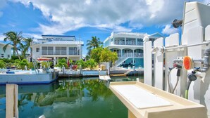 Ein Yachthafen mit vertäuten Booten, ein Poolbereich und ein Gebäude mit einem Balkon.