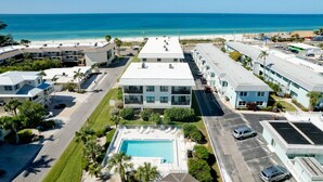 A hotel with a pool, multiple floors, and a view of the beach.