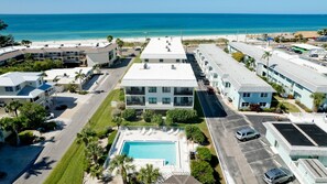 A hotel with a pool, multiple floors, and a view of the beach.