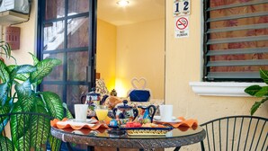 Colazione preparata su un tavolino con vista su una stanza e una finestra con persiane.