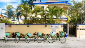 Un edificio con una targa che riporta "Abbey del Sol" e un cartello con la scritta "VACANCY". In primo piano, biciclette parcheggiate.