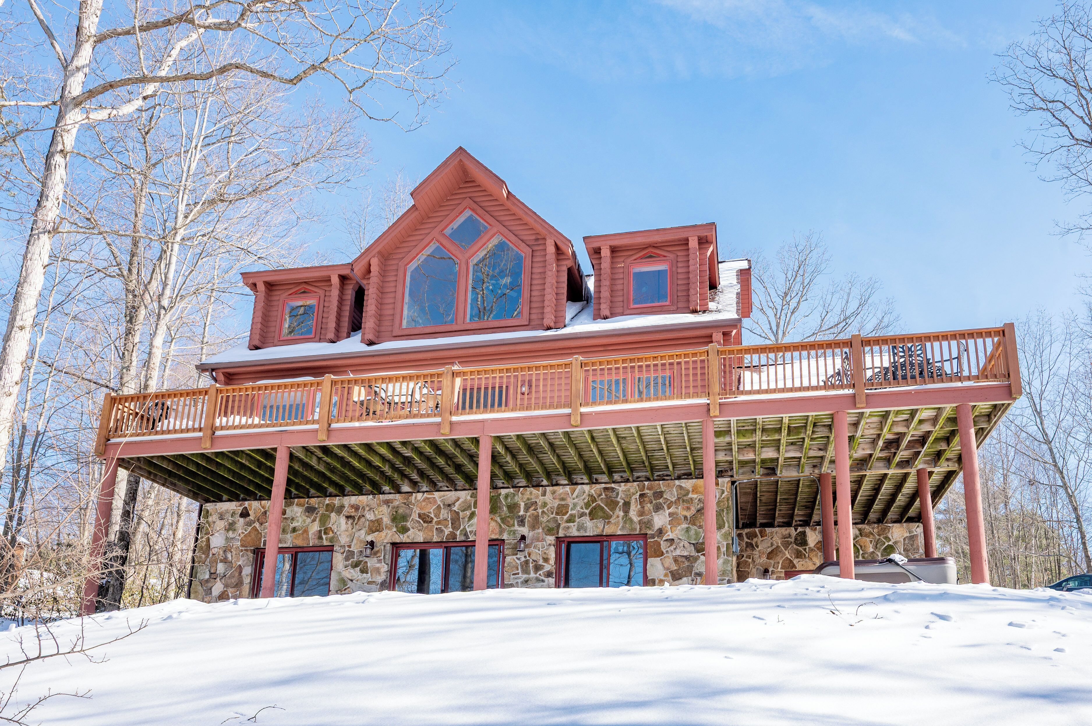 A large, multi-story house with a stone foundation and a wooden balcony.