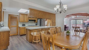 Une cuisine moderne avec des meubles en bois, un îlot central et un coin repas doté de chaises en bois.