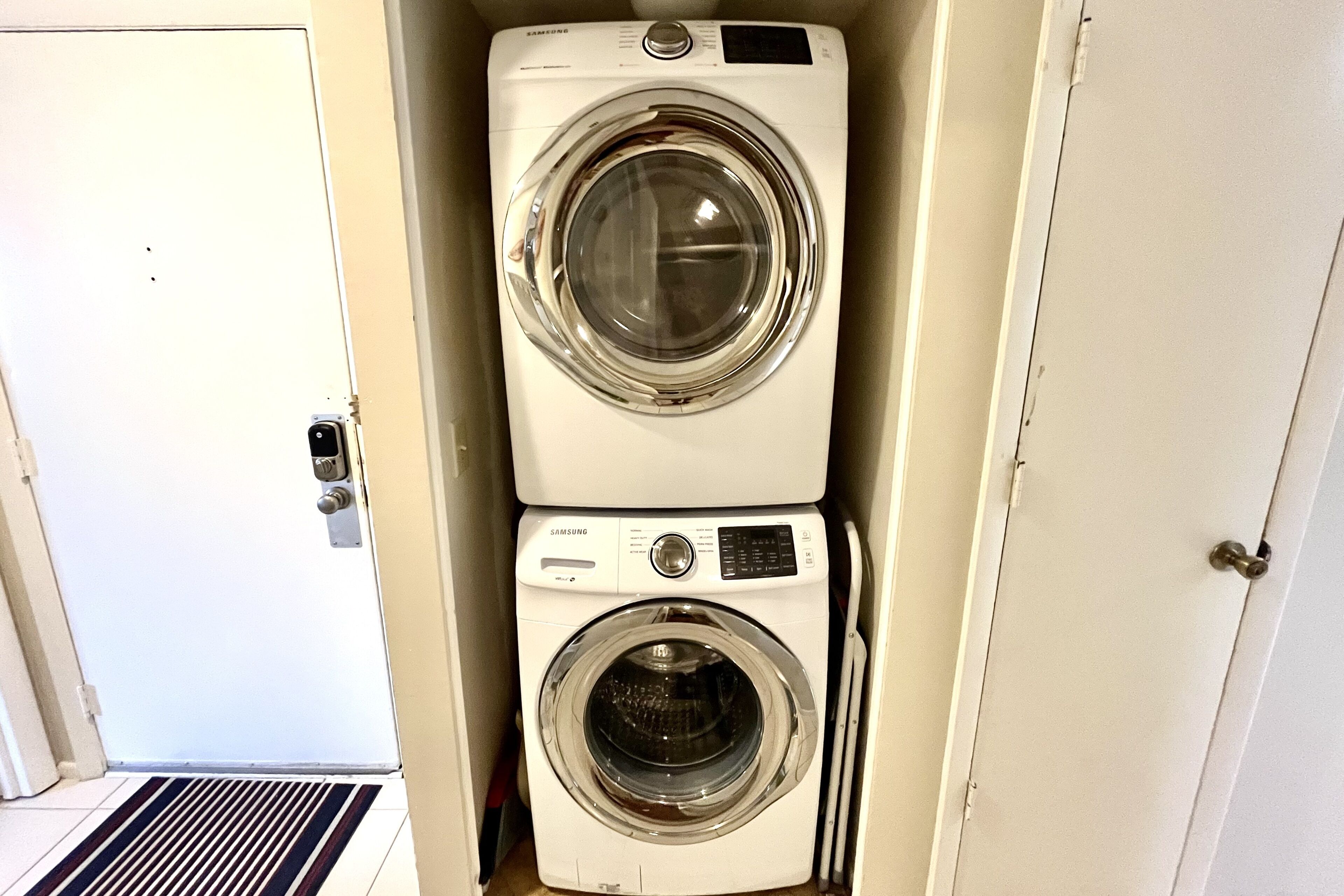 A compact, two-door laundry room with a built-in washer and dryer.