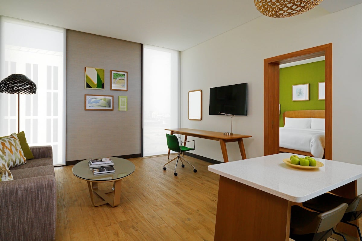 Ein modernes Wohnzimmer mit einer Couch, einem Couchtisch, einem Fernseher und einem Schreibtisch.