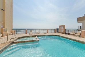 Relax by the ocean-view pool, surrounded by lounge chairs and a seating area.