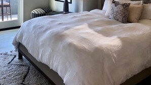 A bedroom with a large bed, a ceiling fan, a window, and a view of the outdoors. - Luxury 2 Bed/2 Bath Penthouse in Shell Beach, Overlooking the Coast with Wrap-Around Balconies (Shell Beach)