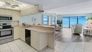 Eine moderne Küche mit Kochinsel, integrierten Geräten und Blick ins Freie.