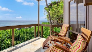 A covered balcony with wooden chairs and a view of the ocean. - Pure Luxury! Chic Kitchen+Bath, Tile Floor, Sunset View Lanai, WiFi, Laundry Kanaloa 1902 (KAILUA-KONA)