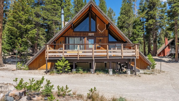 A cabin with a wooden exterior, a balcony, and a chimney. - Chalet #2, Charming Ski In/ Ski Out Steps to the M (Mammoth Lakes)