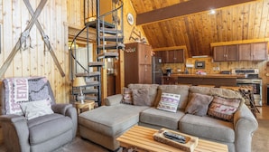 A cozy log cabin interior with a living room, a staircase, and a kitchen area. - Chalet #2, Charming Ski In/ Ski Out Steps to the M (Mammoth Lakes)