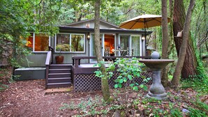 Une cabane dotée d’une terrasse, d’un patio et d’un abreuvoir à oiseaux.