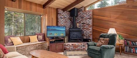 Télévision, cheminée, lecteur de DVD, livres