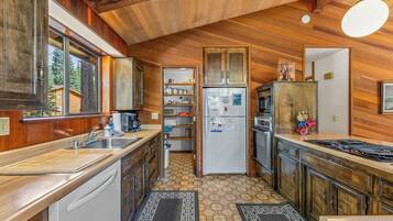 A compact kitchen with wooden cabinets, a built-in oven, and a refrigerator.