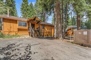 A wooden cabin with a front porch, a staircase, and a mailbox. - Villa Bossi Cabin Adjacent to Forest Land, Wood Stove, Full Kitchen, Deck Pets Welcome! (Carnelian Bay)