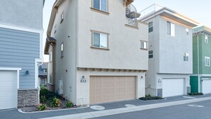 Un immeuble résidentiel à la façade beige, doté d’un garage et d’un petit balcon.