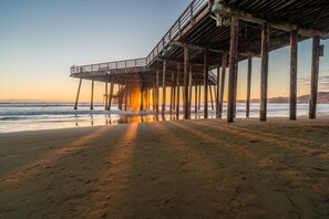 A pier extending into the ocean with a clear sky above.