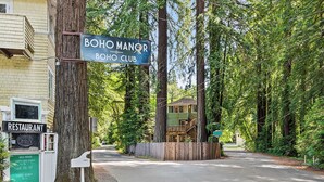 A sign for Boho Manor Boho Club, a restaurant, and a wooden fence. - Monte Rio Treehouse ~ Dog Friendly, Redwoods, Walk to Restaurants and River (Monte Rio)