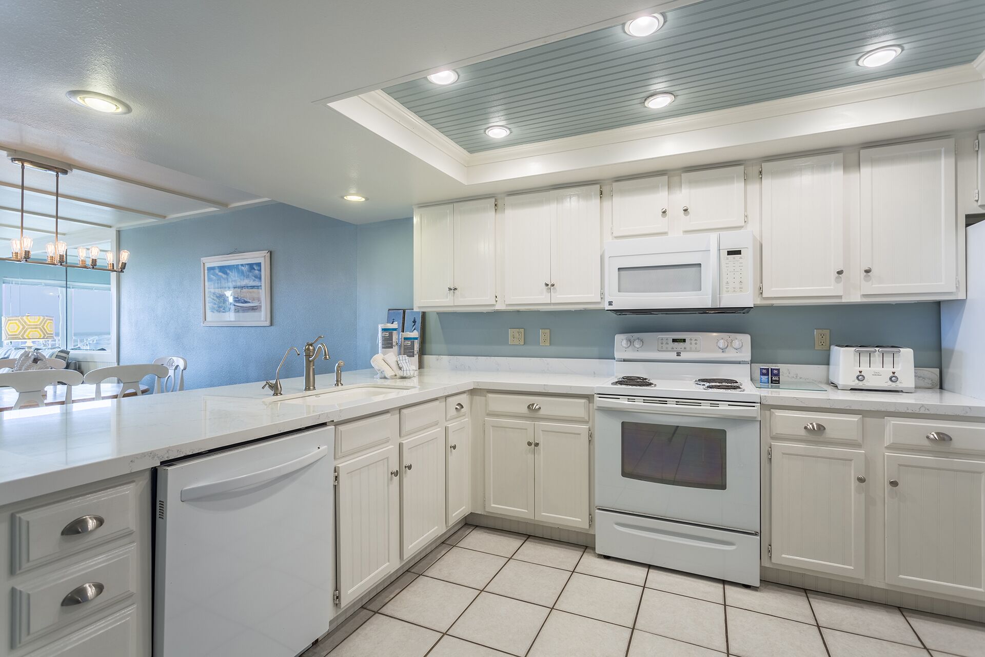 A modern kitchen with white cabinets, a built-in microwave, a stove, and a dishwasher.