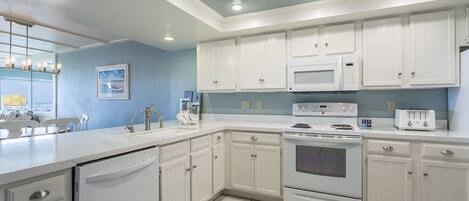 A modern kitchen with white cabinets, a built-in microwave, a stove, and a dishwasher.
